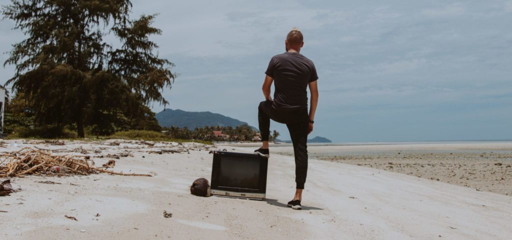 man with TV on a beach